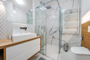 a bathroom with a sink and a shower at Gardenia, Sun & Snow in Dziwnów