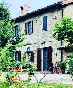 an old stone house with a table in front of it at La Petriola Casa Vacanze in Gubbio