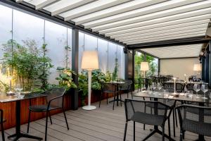 a restaurant with tables and chairs and plants at Hôtel Villa KOEGUI Bayonne in Bayonne