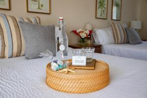 a tray with a bottle and glasses on a bed at Sesuit Harbor House in East Dennis