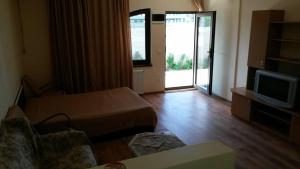 a living room with a bed and a tv and a couch at Vila Zuzette in Constanţa