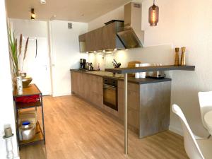 una cucina con elettrodomestici in acciaio inossidabile e pavimenti in legno di Studio mit Panorama-Meerblick und direkter Strandlage in Scharbeutz a Scharbeutz