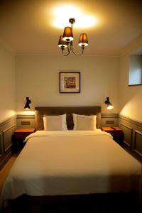 a bedroom with a large white bed with two lamps at Central Boutique Apartments in Sighişoara