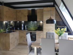 uma cozinha com armários de madeira e uma mesa e cadeiras em Haus Rosengarten mit Sauna em Bad Wünnenberg