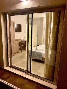 una ventana corredera de cristal con vistas a un dormitorio en Club Esse Cala Bitta en Baja Sardinia
