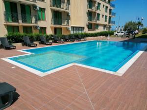 a swimming pool in front of a building at Golden Dunes Primorsko Apartments in Primorsko