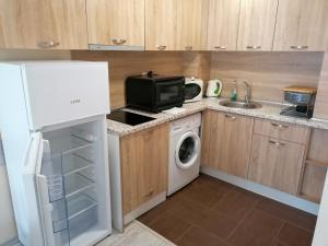 a small kitchen with a microwave and a washer and dryer at Golden Dunes Primorsko Apartments in Primorsko