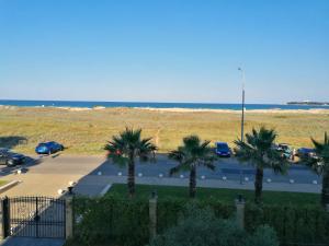 a parking lot with palm trees and the ocean at Golden Dunes Primorsko Apartments in Primorsko