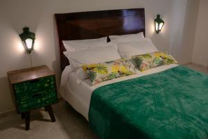 a bedroom with a bed with two pillows and a night stand at Pousada Rua de Lazer in Domingos Martins