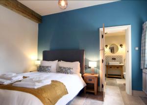 a bedroom with a blue wall and a bed at Mount Pleasant Cottages in Richmond