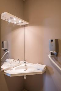 uma casa de banho com um lavatório branco e um espelho. em Hôtel L'Horizon - Restaurant La Fougassette em Saint-Symphorien-sur-Coise