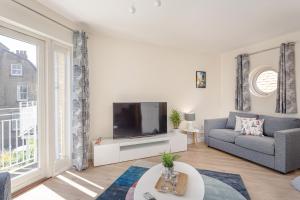 uma sala de estar com um sofá e uma televisão em 2 Bedroom City Centre Townhouse - with Parking em Cambridge