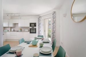 a white dining room with a table and chairs at 2 Bedroom City Centre Townhouse - with Parking in Cambridge