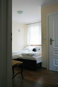 1 dormitorio con 2 camas y ventana en Pokoje Gościnne w Ratuszu, en Ogrodzieniec