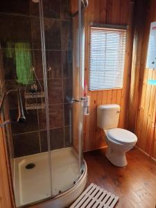 a bathroom with a toilet and a glass shower at Honne-Pondokkies in Hondeklipbaai