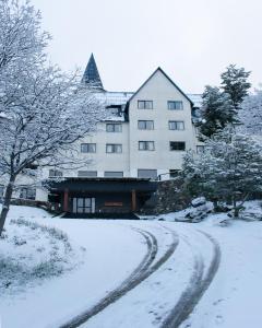 uma estrada coberta de neve em frente a um edifício em Las Hayas Ushuaia Resort em Ushuaia