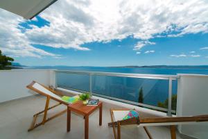 einen Balkon mit einem Stuhl und Blick auf das Wasser in der Unterkunft Abuela's Beach House in Brela