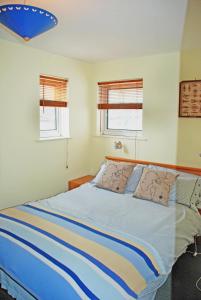 イースト・カウズにあるAisla Cottage • East Cowes • Isle of Wightのベッドルーム1室(青と白のシーツが備わるベッド1台付)