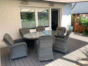 - un groupe de chaises et une table sur une terrasse couverte dans l'établissement Adult only klimatisierte Ferienwohnung in Schwerte, à Schwerte