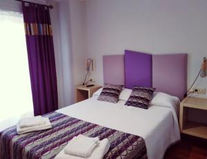 a bedroom with a large bed with two pillows at Descanso do Sar in Santiago de Compostela
