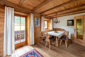 - une salle à manger dans une cabane en rondins avec une table et des chaises dans l'établissement Villa al Bosco, à Selva di Val Gardena