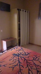 a bedroom with a bed with a tree pattern on it at Auberge Le Baobab in Saly Portudal