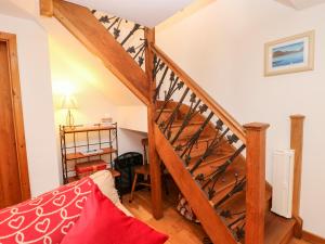a room with a staircase with a red bed at Chapel Cottage in Sandford