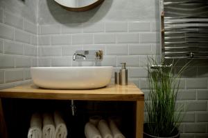 a bathroom with a white sink on a wooden counter at Central Boutique Apartments in Sighişoara +36 photos
