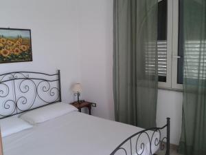 um quarto com uma cama branca e uma janela em Azienda Agrituristica B&B La Torre em Vignacastrisi