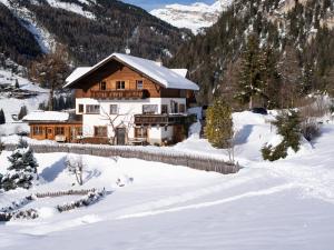 a log cabin in the snow with a fence at Villa al Bosco in Selva di Val Gardena