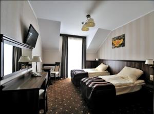 una camera d'albergo con due letti e un divano di HOTEL NIAGARA a Konin