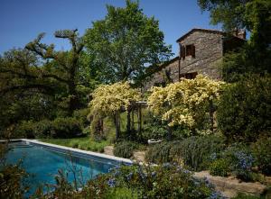 a swimming pool in front of a stone house at Montauto Suites in Chianciano Terme