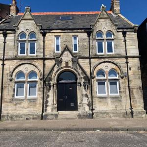 an old stone building with a black door at Ayr Riverside Apartments in Ayr