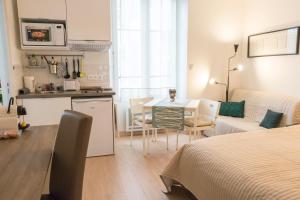 kuchnia i salon z łóżkiem i stołem w obiekcie Le Gérémoy w mieście Vittel