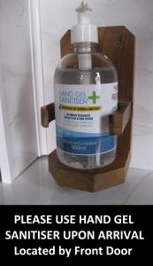 a bottle of hand gel sanitizer in a wooden holder at Perfect for Petersfield B&B in Petersfield