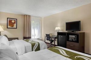 a hotel room with two beds and a flat screen tv at Quality Inn High Point - Archdale in Archdale