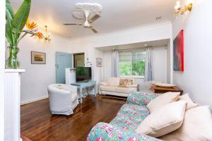 ein Wohnzimmer mit einem Sofa und einem Tisch in der Unterkunft Camellia Cottage - PET FRIENDLY - Kwinana in Medina