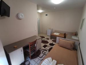 a room with a desk and a couch and a table at Hostel Penev in Stara Zagora