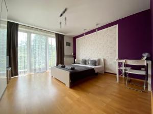 a bedroom with a bed and a purple wall at Pokoje Rezydencja Parysa in Lublin