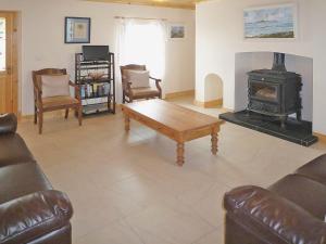 a living room with a couch and a wood stove at Timmys Cottage Heir Island by Trident Holiday Homes in Skibbereen
