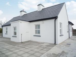 a white garage with a pitched roof at Timmys Cottage Heir Island by Trident Holiday Homes in Skibbereen