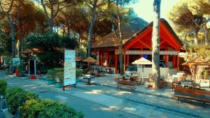a building with benches and umbrellas in a park at Buona Mobile Homes on Camping Mare e Pineta in Lido di Spina