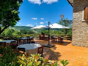 a patio with tables and chairs and umbrellas at Agriturismo La Fine in Piancaldoli