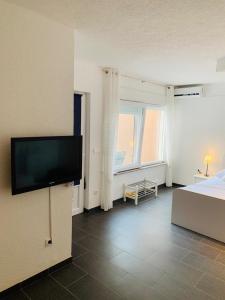 a bedroom with a bed and a flat screen tv at Apartments Villa Zica in Trogir