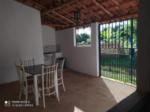 Habitación con mesa, sillas y balcón. en Hospedaria Villa Mariana en Santo Antônio do Leite