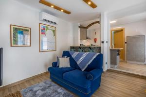 - un canapé bleu dans un salon avec une cuisine dans l'établissement Villa Santa Bárbara, à Vila Nova de Gaia
