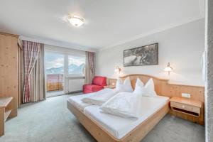 pokój hotelowy z łóżkiem i czerwonym krzesłem w obiekcie Gasthof und Hotel Rieder GmbH w mieście Jenbach