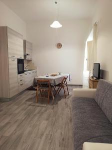 a living room with a table and a kitchen at A Casa di Santé in Arnesano