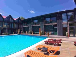 a swimming pool with lounge chairs next to a building at Green House Garden Park Hotel in Istanbul
