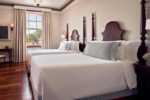 2 große weiße Betten in einem Zimmer mit Fenster in der Unterkunft Hotel das Cataratas, A Belmond Hotel, Iguassu Falls in Foz do Iguaçu